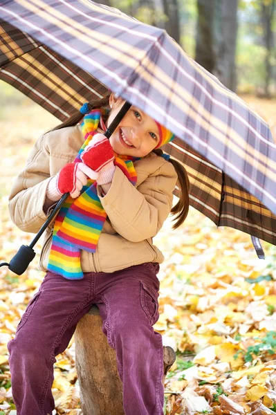 Menina criança na floresta de outono com guarda-chuva, bela paisagem na temporada de outono com folhas amarelas — Fotografia de Stock