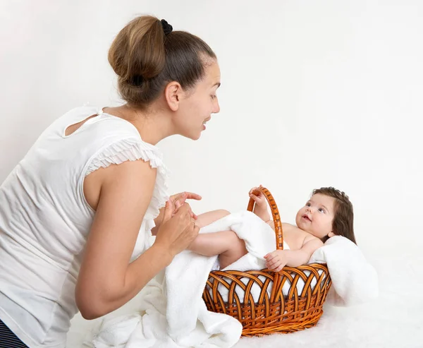 Mother talk with baby in basket on white towel, family concept — Stock Photo, Image