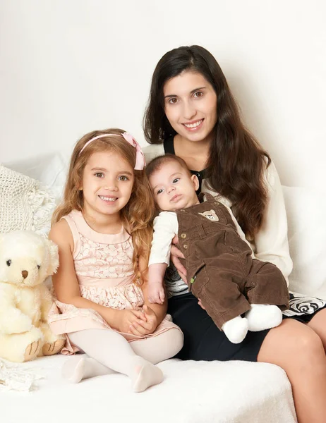 Madre con i figli seduta nel letto con orsacchiotto, felice ritratto di famiglia — Foto Stock