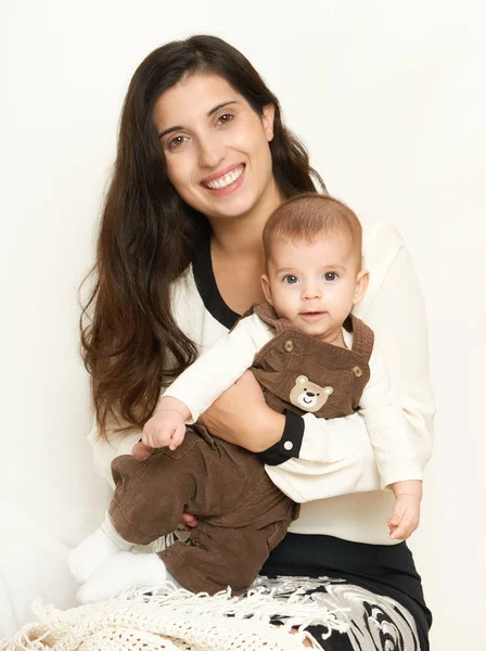 Mãe com bebê, retrato de família feliz no fundo branco, amarelo tonificado — Fotografia de Stock