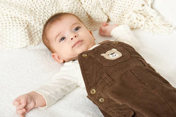 Baby portrait lie on white towel in bed, yellow toned — Stock Photo, Image