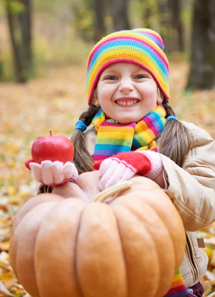 Girl child in autumn forest with pumpkin and apples, beautiful landscape in fall season with yellow leaves — Stock Photo, Image