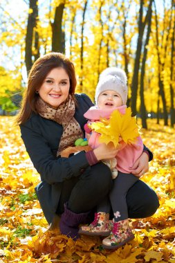 Kadın sonbahar Şehir Parkı, mutlu bir aile içinde çocuk kızla