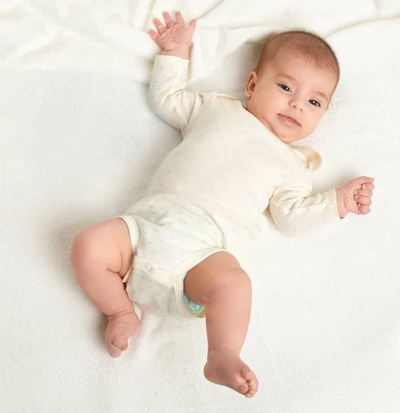 Baby lie on white towel in bed, top view — Stock Photo, Image