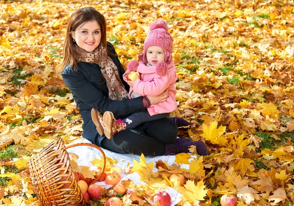 Woman with child girl in autumn city park, happy family — Stock Photo, Image
