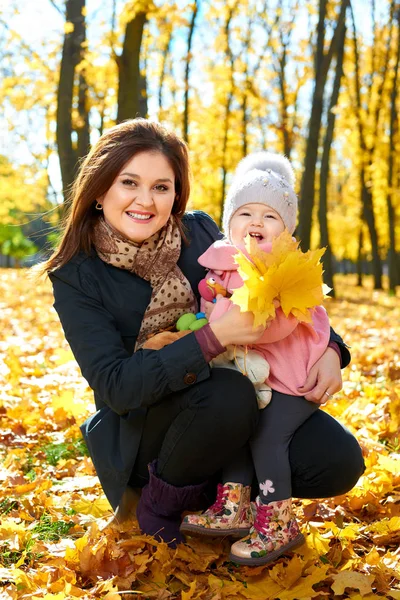 Femme avec enfant fille dans le parc de la ville d'automne, famille heureuse — Photo