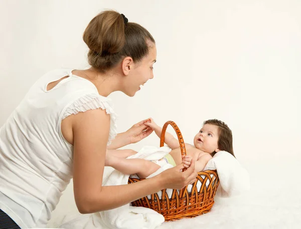 Rozmowa matki z dzieckiem w koszyku na biały ręcznik, pojęcie rodziny, żółty stonowanych — Zdjęcie stockowe