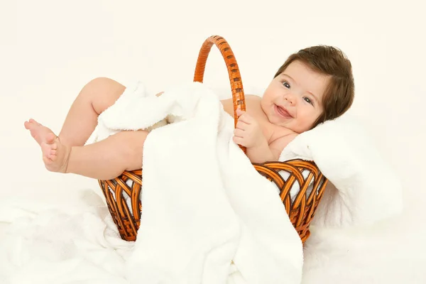Baby in basket on white towel, healthcare concept, yellow toned — Stock Photo, Image
