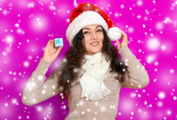 Ragazza in ritratto di Babbo Natale con piccola scatola regalo in posa su sfondo di colore rosa, concetto di festa di Natale, felice ed emozioni — Foto Stock