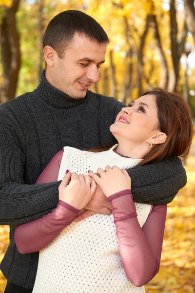 Romantische Menschen, glückliches erwachsenes Paar umarmt sich im herbstlichen Stadtpark, Bäume mit gelben Blättern, strahlende Sonne und glückliche Emotionen, Zärtlichkeit und Gefühle — Stockfoto