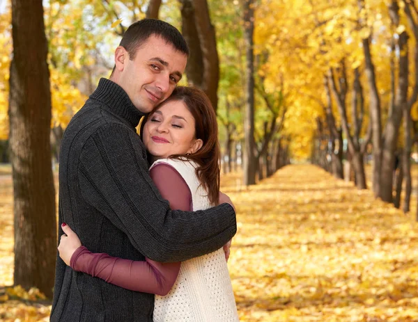 Pessoas românticas, casal adulto feliz abraçar no parque da cidade de outono, árvores com folhas amarelas, sol brilhante e emoções felizes, ternura e sentimentos — Fotografia de Stock