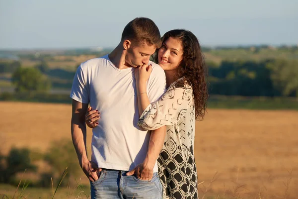 Щаслива молода пара високо позує на кантрі над жовтим полем, концепція романтичних людей, літній сезон — стокове фото