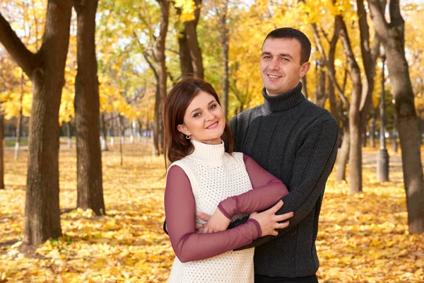 Romantische Menschen, glückliches erwachsenes Paar umarmt sich im herbstlichen Stadtpark, Bäume mit gelben Blättern, strahlende Sonne und glückliche Emotionen, Zärtlichkeit und Gefühle — Stockfoto