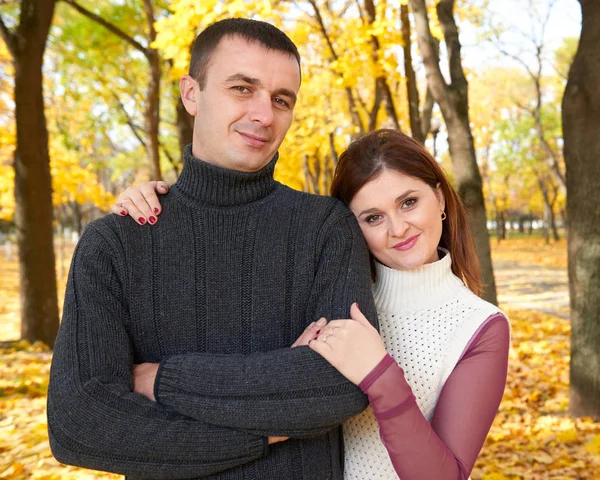 Romantische Menschen, glückliches erwachsenes Paar umarmt sich im herbstlichen Stadtpark, Bäume mit gelben Blättern, strahlende Sonne und glückliche Emotionen, Zärtlichkeit und Gefühle — Stockfoto