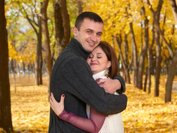 Romantiska människor, glada vuxna par omfamna i höst stadspark, träd med gula blad, strålande sol och glada känslor, ömhet och känslor — Stockfoto