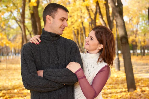 Romantische Menschen, glückliches erwachsenes Paar umarmt sich im herbstlichen Stadtpark, Bäume mit gelben Blättern, strahlende Sonne und glückliche Emotionen, Zärtlichkeit und Gefühle — Stockfoto