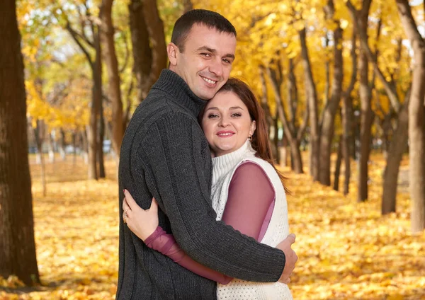 Romantiska människor, glada vuxna par omfamna i höst stadspark, träd med gula blad, strålande sol och glada känslor, ömhet och känslor — Stockfoto