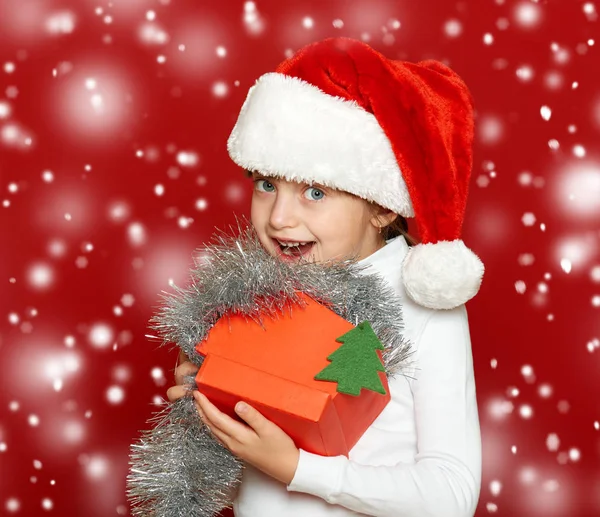 Retrato de criança menina com caixa de presente no vermelho, conceito de feriado de Natal — Fotografia de Stock