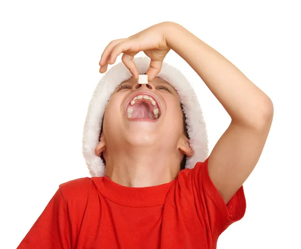 Boy child eat sugar in santa hat, having fun and emotions, winter holiday concept — Stock Photo, Image