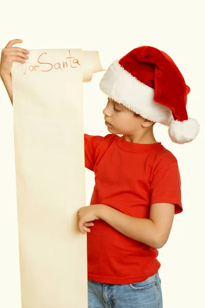 Garçon en chapeau rouge avec un long défilement souhaite Père Noël - concept de Noël vacances d'hiver, ton jaune — Photo