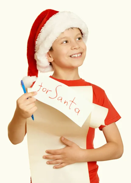 Ragazzo in cappello rosso con lunghi desideri di pergamena a Babbo Natale concetto di vacanza invernale, tonica gialla — Foto Stock