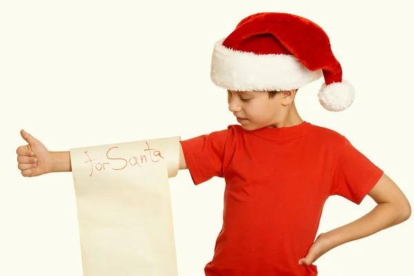 Ragazzo in cappello rosso con lunghi desideri di pergamena a Babbo Natale concetto di vacanza invernale, tonica gialla — Foto Stock