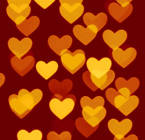 Fondo bokeh corazón, objetos foto borrosa, amarillo sobre marrón oscuro — Foto de Stock