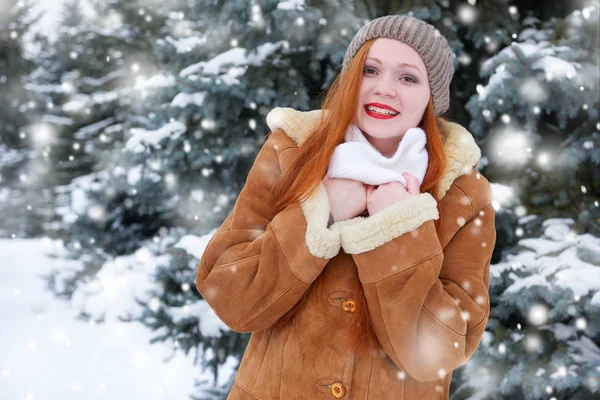 Bela mulher no inverno ao ar livre, abetos nevados na floresta, cabelos longos vermelhos, vestindo um casaco de pele de carneiro — Fotografia de Stock