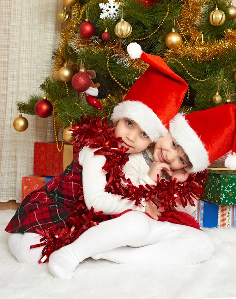 Портрет двух девушек в рождественском оформлении, концепция зимнего праздника, украшенная елка и подарки — стоковое фото