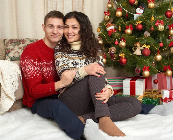 Coppia felice con Natale e regalo di Capodanno a casa. Abete con decorazione. Concetto vacanza invernale. Famiglia sorridente insieme . — Foto Stock