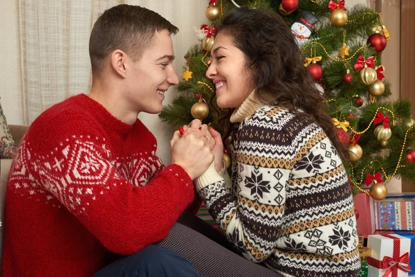 幸福的夫妇与圣诞节和新年的礼物在家里。枞树装饰。冬天假日概念。微笑的家人在一起. — 图库照片