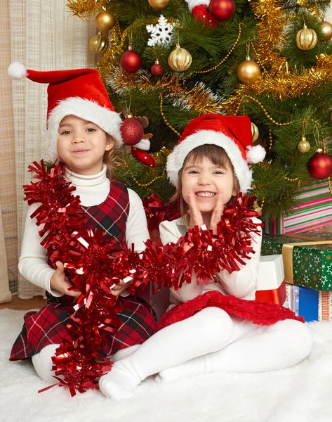 iki kız portre Noel dekorasyonu, kış tatil kavramı, süslü çam ağacı ve hediyeler