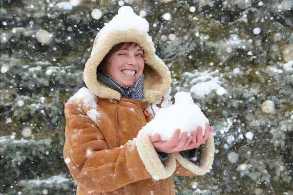 겨울 야외, 눈 덮인 전나무 숲에 양 가죽 코트를 입고, 눈으로 아름 다운 여자 플레이 — 스톡 사진