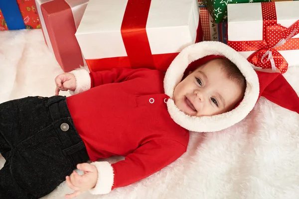 Retrato del bebé feliz en la decoración de Navidad, mentira en la piel cerca del abeto y los regalos, concepto de vacaciones de invierno — Foto de Stock