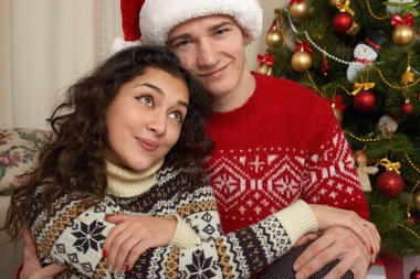 Mutlu çiftimiz Noel dekorasyonu evde. Yeni yıl arifesi, köknar ağacı dekore edilmiştir. Kış tatil ve sevgi kavramı.