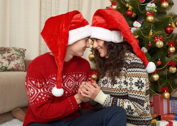 Coppia giovane nella decorazione natalizia. Interno casa con regali e abete. Concetto di vacanza di anno nuovo. Amore e tenerezza . — Foto Stock