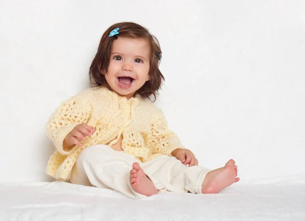 Kleines Mädchen sitzt auf weißem Handtuch, fröhliche Emotion und Gesichtsausdruck — Stockfoto