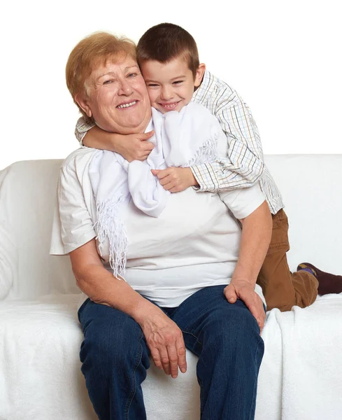 Grandmother and grandchild family portrait on white background, happy people sit on sofa. — Stock Photo, Image