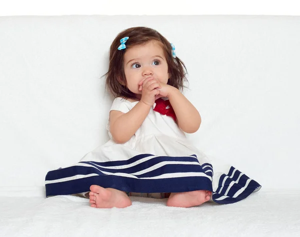 Happy little child girl sit on white towel, happy emotion and face expression, very surprised, the finger in mouth — Stock Photo, Image