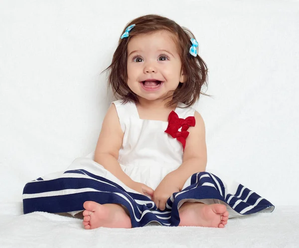 Niña pequeña y feliz sentarse en una toalla blanca, emoción feliz y expresión de la cara — Foto de Stock