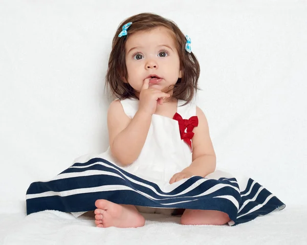 Glad liten barn flicka sitta på vit handduk, glada känslor och ansikte uttryck, mycket förvånad, fingret i munnen — Stockfoto