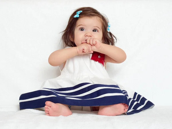 Glad liten barn flicka sitta på vit handduk, glada känslor och ansikte uttryck, mycket förvånad, fingret i munnen — Stockfoto