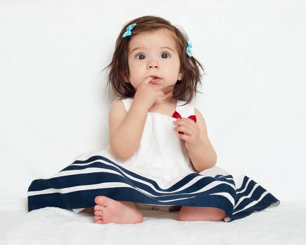 Glad liten barn flicka sitta på vit handduk, glada känslor och ansikte uttryck, mycket förvånad, fingret i munnen — Stockfoto