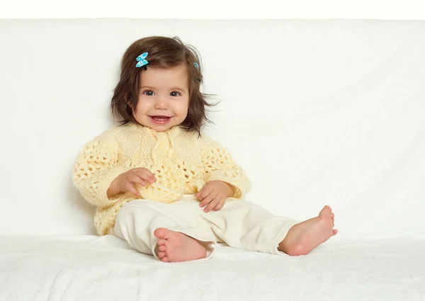 Menina pequena feliz sentar-se na toalha branca, emoção feliz e expressão facial, tonificado amarelo — Fotografia de Stock