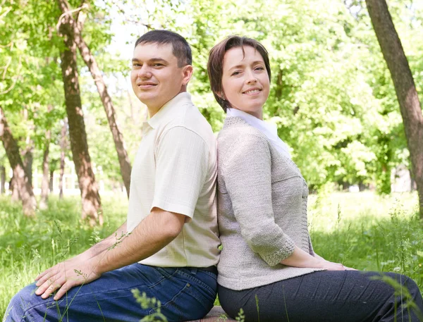 Happy couple portrait. City park in summer season. Beautiful landscape with trees and green grass Royalty Free Stock Images