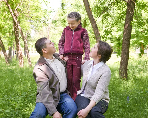 Happy family and child in summer park, beautiful landscape with trees and green grass — Stock Photo, Image