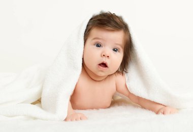 Adorably yalan yatakta beyaz havlu üzerine bebeğim. Mutlu çocukluk ve sağlık kavramı. Sarı tonda