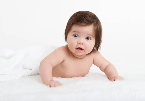 Uroczo baby kłamstwo na ręcznik w łóżku, białe tło. Szczęśliwe dzieciństwo i koncepcji opieki zdrowotnej — Zdjęcie stockowe