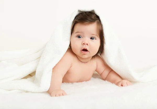 Adorably baby lie on white towel in bed. Happy childhood and healthcare concept. Yellow toned — Stock Photo, Image