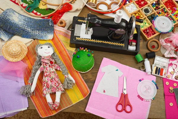 Лялька ручної роботи та візерунок одягу, швейні аксесуари вид зверху, швачка робоче місце, багато предметів для рукоділля, вишивки та ручної роботи — стокове фото
